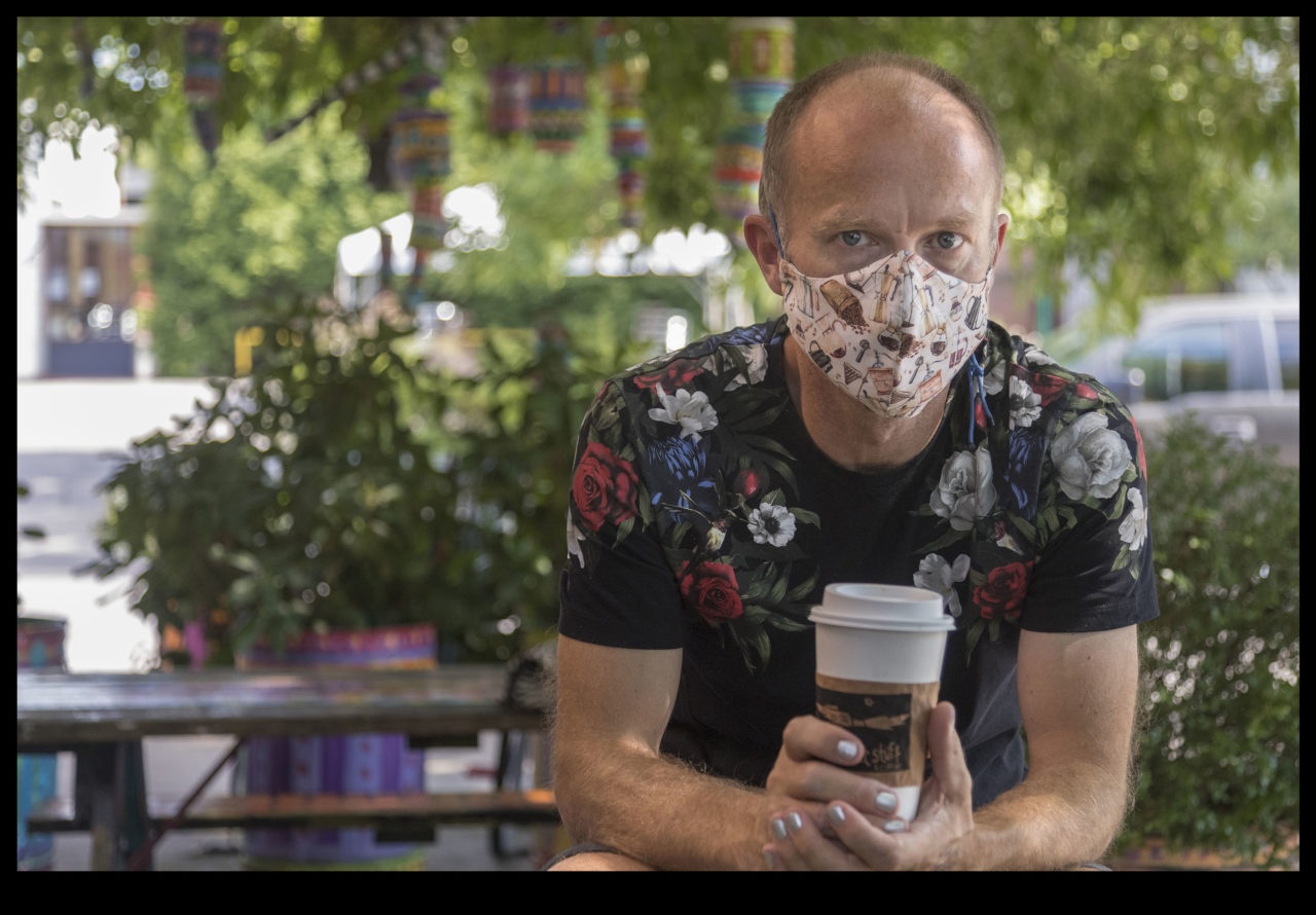 Kurt Godhe wearing a floral print shirt and patterned face mask.